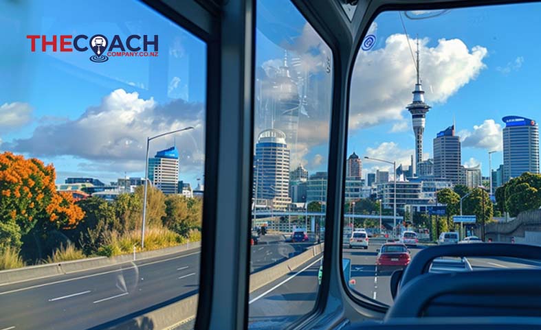 Auckland skyline viewed from a hired bus window, showcasing the city's iconic Sky Tower.